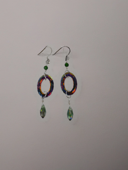 Colorful earrings with circular designs and green beads on a gray background