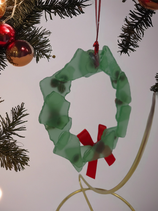 Green wreath ornament with red center on a Christmas tree